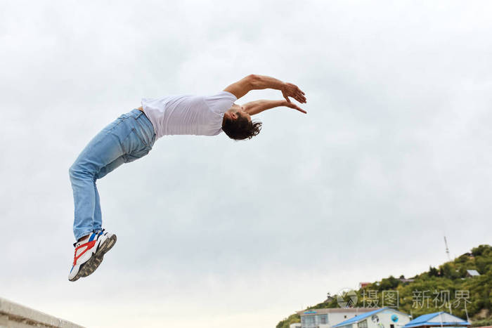 穿着白色t恤和牛仔裤的勇敢的家伙弯着腰