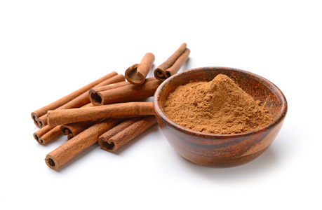 粉末调料白色背景的芳香肉桂棒和粉末照片