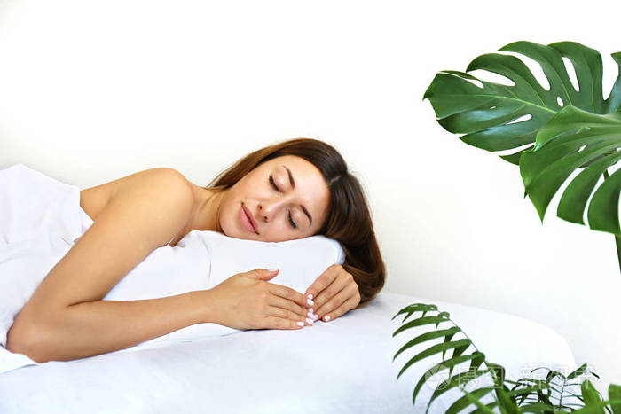 早上醒来后躺在床上的年轻美女昏昏欲睡的黑发女性面