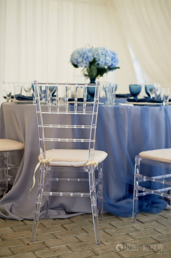 婚礼宴会厅的婚礼装饰蓝色绣球花透明椅子