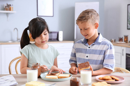 烤面包孩子有趣的小孩子在厨房里吃美味的烤面包照片