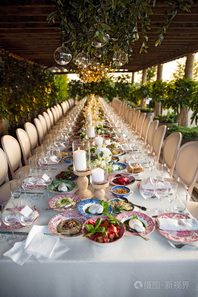 在餐厅举行户外婚礼庆典节日餐桌布置餐饮夏日乡村风格婚礼桌上摆着