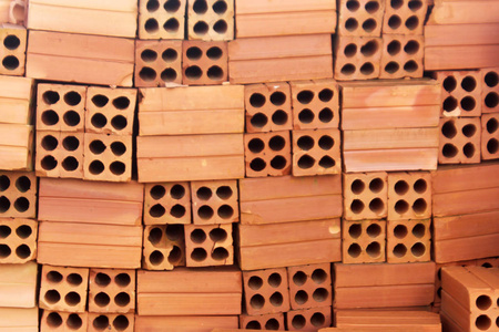 堆新砖橙色粘土4孔砖堆的特写镜头.照片