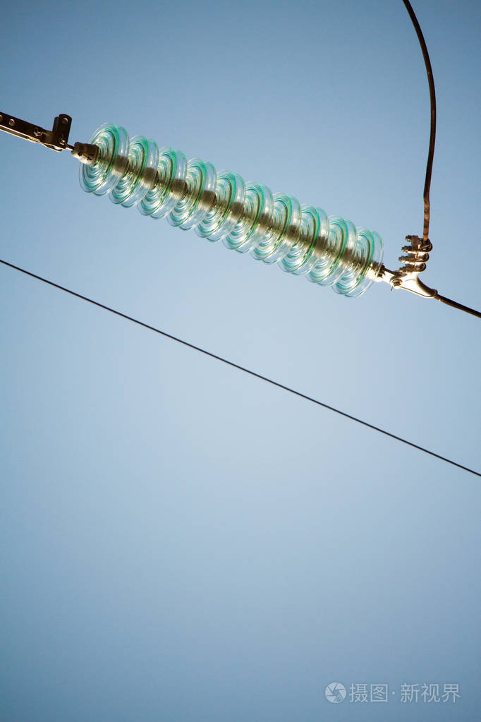 蓝天下的高压电线绝缘体的特写俯视图