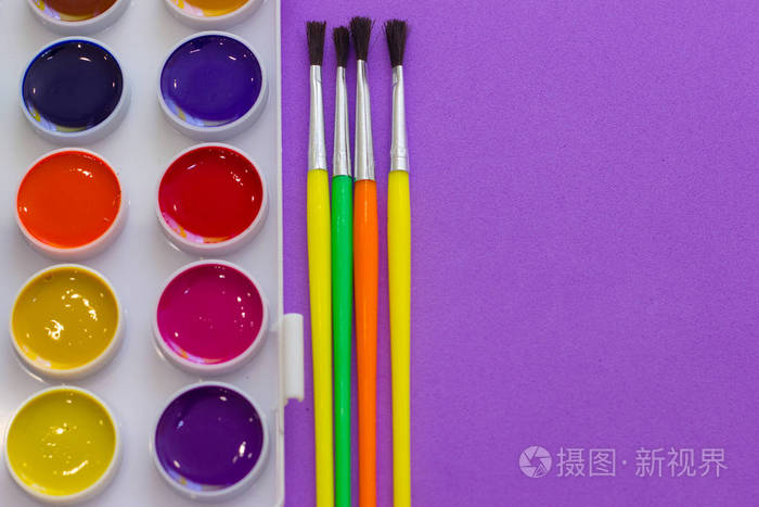 在紫色背景俯视图上绘制画笔和调色板回到学校