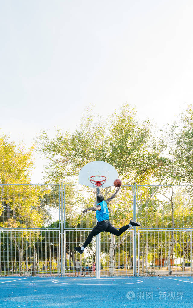 在街头篮球场上打球的非洲青年