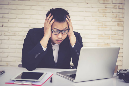 商人坐在办公室里闷闷不乐的商人照片