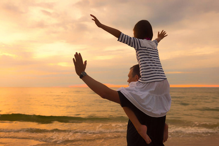 爸爸背在夕阳的背景下,爸爸肩上的孩子照片