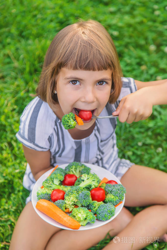 孩子吃蔬菜花椰菜和胡萝卜选择性聚焦