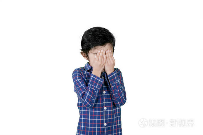 悲伤的小男孩在画室里捂着脸