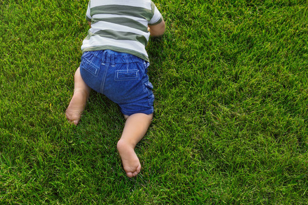 可爱的小宝宝在户外的绿草上爬行,特写插画