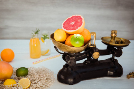 新鲜的柑橘类水果和一些橘子,柠檬,葡萄柚,酸橙和自制饮料摆在白色的