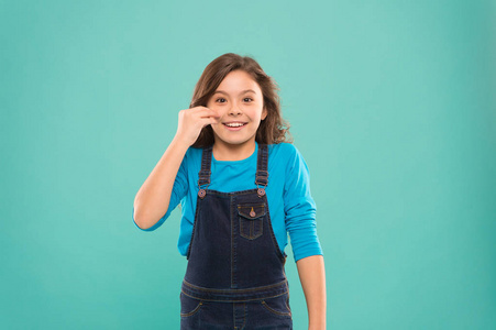 有两个尾巴深思熟虑地抬起手指到多汁的嘴唇,完美的化妆风格的婴儿脸