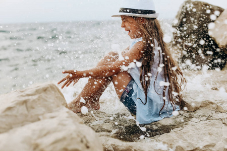 女孩海边的石头是湿的浪花图片