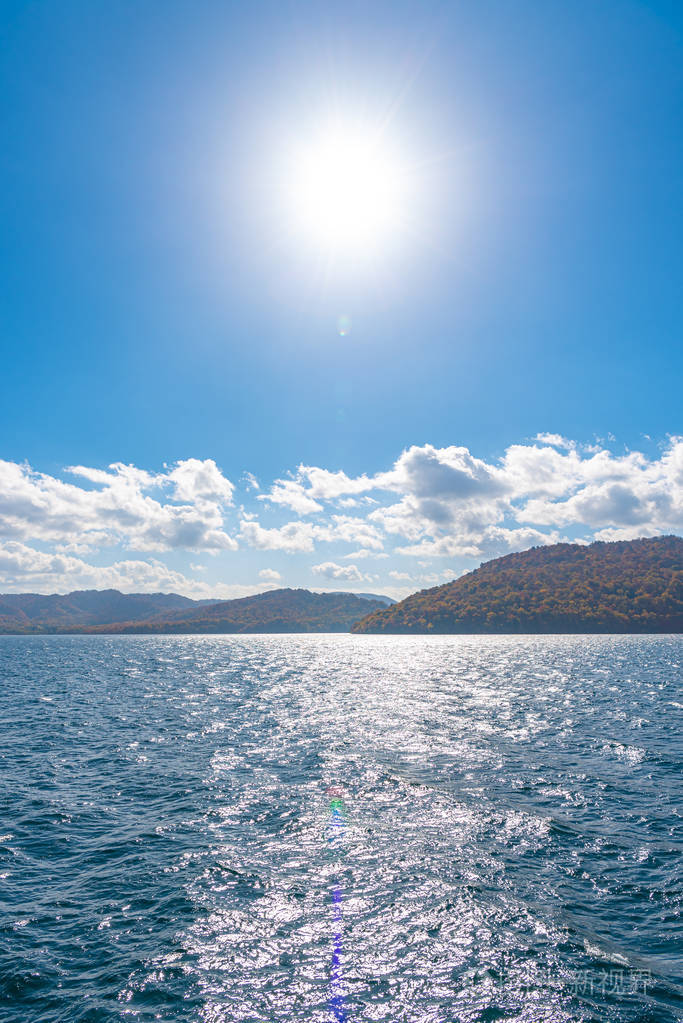 从陶瓦达湖畔眺望,蓝天碧水,白云,阳光明媚的背景.日本青森县