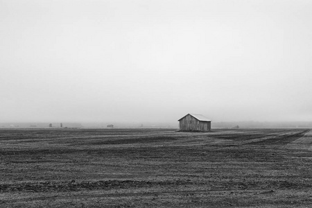 雾气缭绕的田野上孤独的谷仓屋图片