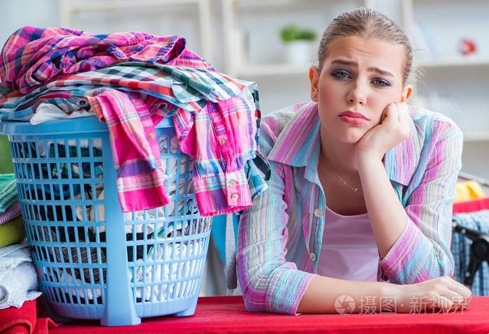 疲惫沮丧的家庭主妇在洗衣服