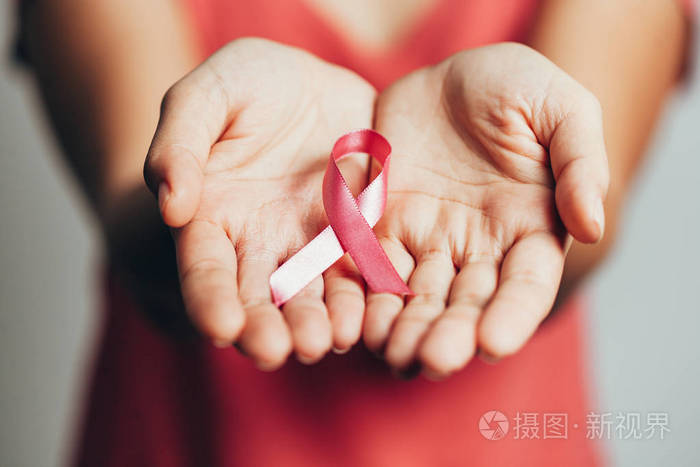 保健和医学概念女性手拿粉红色乳腺癌宣传丝带
