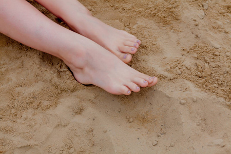 旅游概念.在沙滩上放松,双脚放在沙滩上.照片