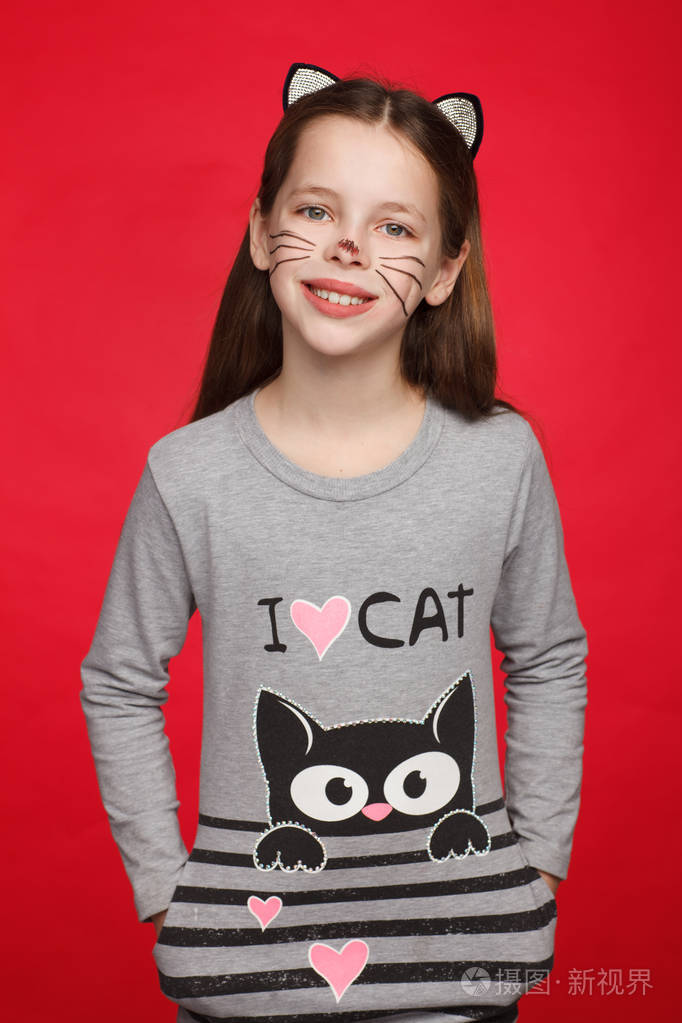 一个快乐的8岁女孩的画像穿着带有猫图案和猫妆的裙子