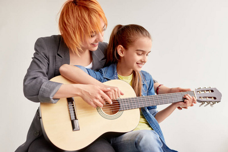 勤奋女孩与个别老师学习弹吉他图片