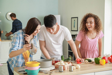快乐的朋友一起在厨房做饭照片