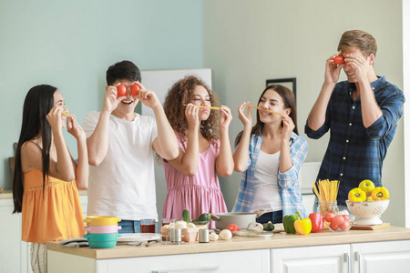 快乐的朋友们一起在厨房做饭,玩得开心照片