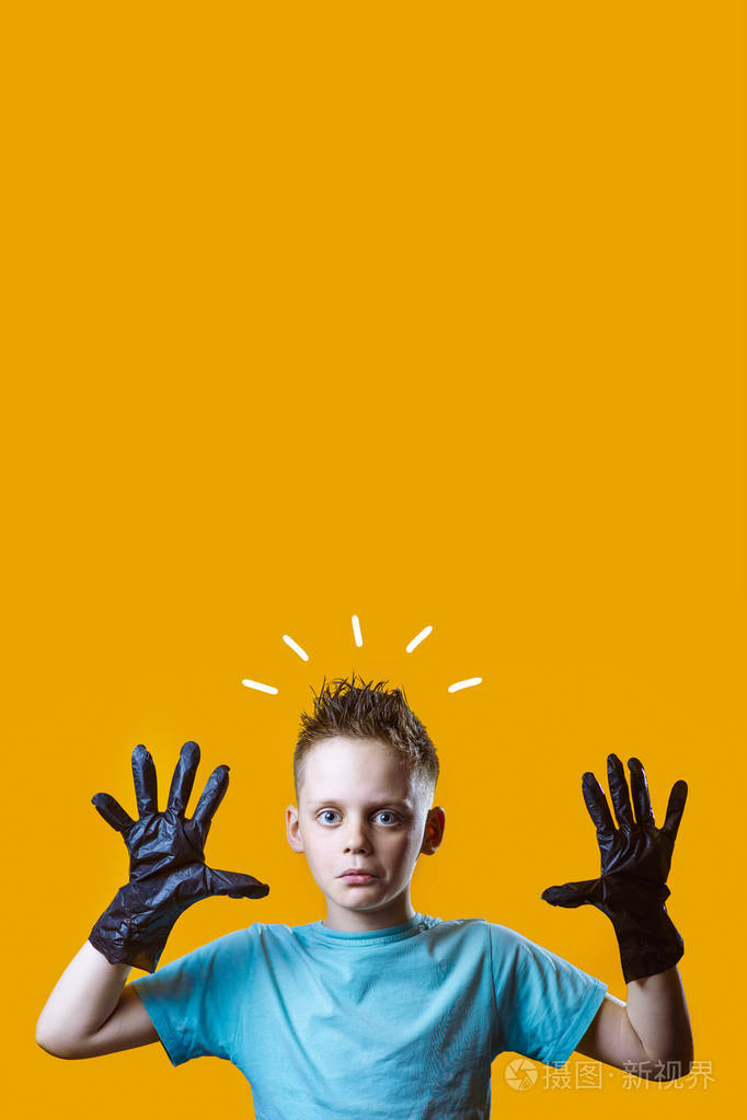 一个穿着黑色手套和黄色背景蓝色t恤的男孩很惊讶