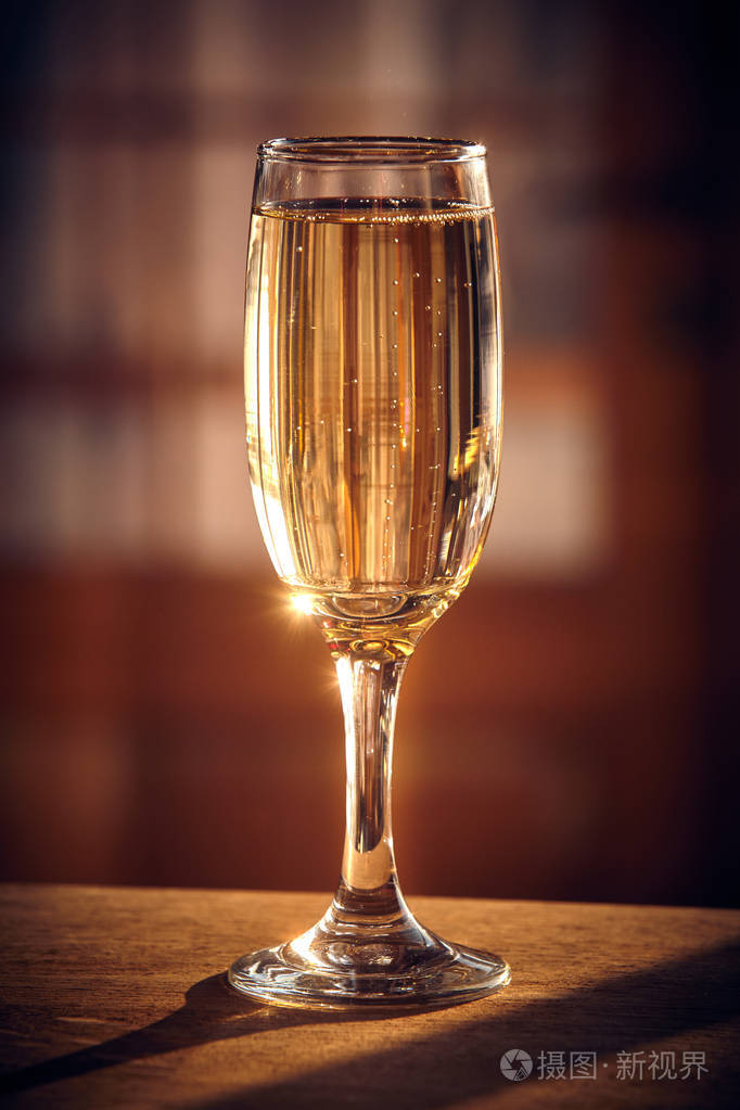 一张木桌上的香槟酒杯阳光和泡泡