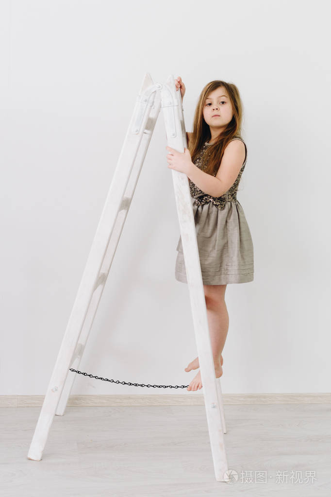 站在白色梯子上的漂亮小女孩