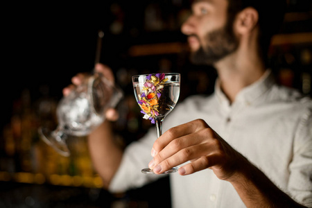 在杯子里拿着奶油甜点的女孩与红色指甲可爱的孩子在房间里站着喝着