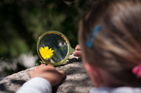 用放大镜探索自然的女孩照片