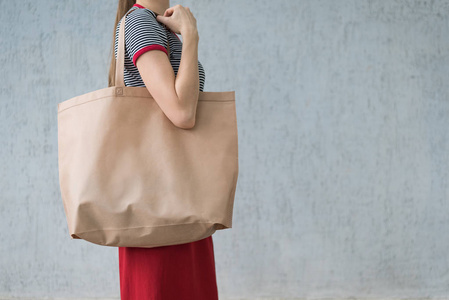 一个年轻女人背着一个大环保袋购物.设计空间照片