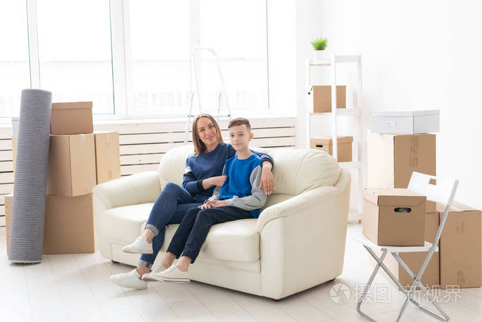 年轻可爱的单身母亲和儿子对搬进新房子很高兴乔迁和家庭空间扩展的