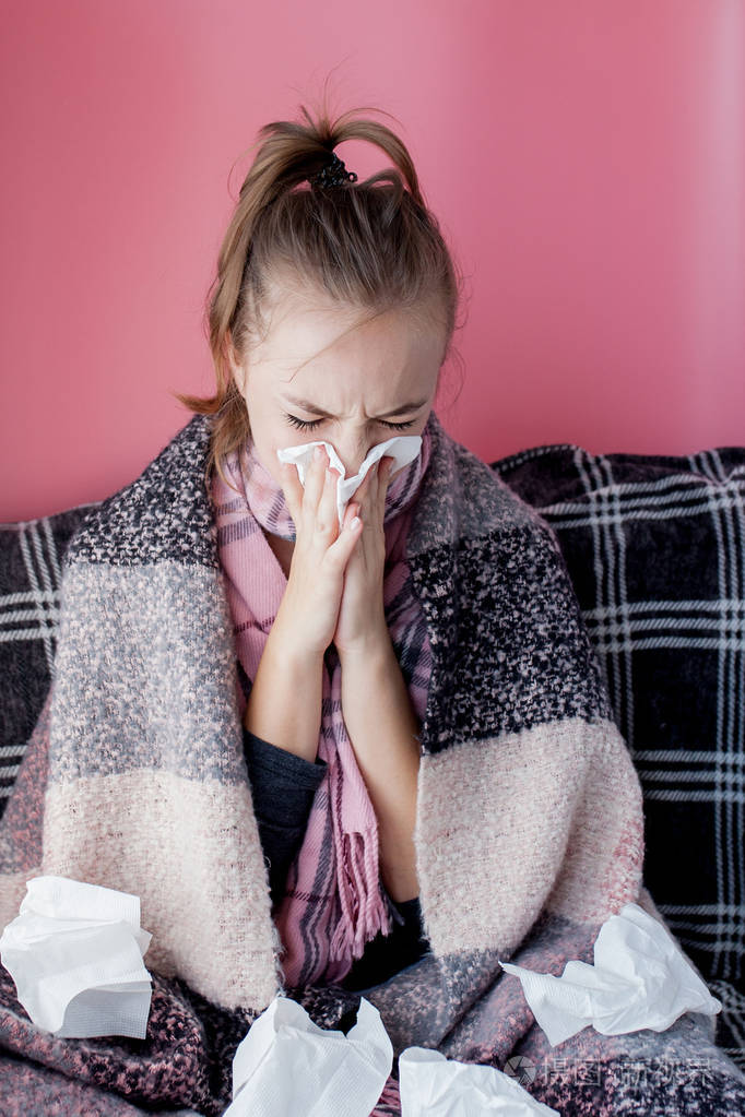 一个年轻的女孩一个手帕和流鼻涕的侧面打喷嚏的流感白色皮肤的女模特