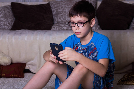 科技,网络交流和人的概念-男孩与智能手机短信或玩游戏在家照片