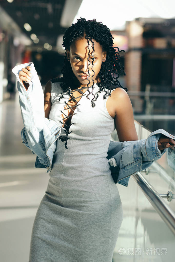 年轻的深色皮肤女人在商场里穿着便装