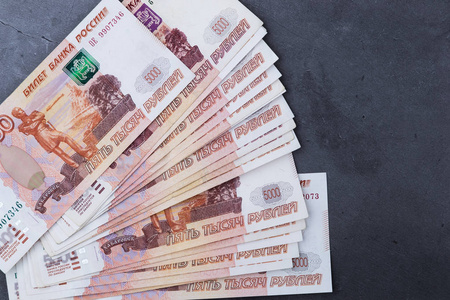 一大摞五千卢布的俄罗斯躺在灰色的水泥地上.照片