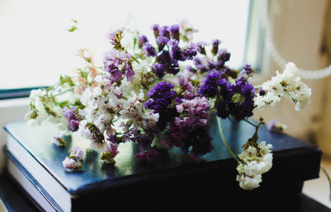干枯的花一束干枯的紫罗兰,粉色和白色野花躺在书上.