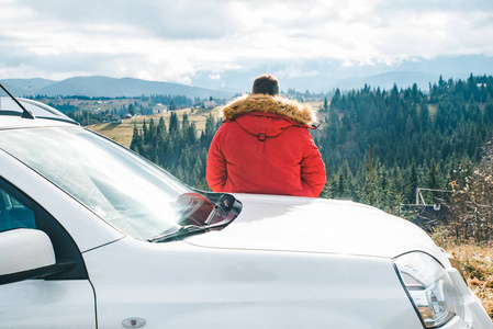四轮驱动概念男人靠在车上看美丽的山景.越野概念.照片