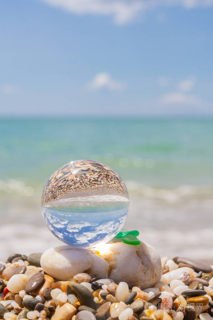 海滩上的玻璃圆球反映了夏天的大海