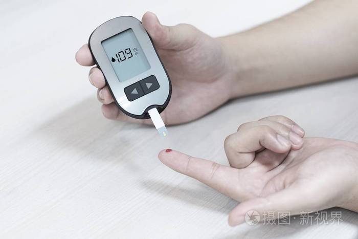 糖尿病患者在家里用血糖仪测量血糖水平