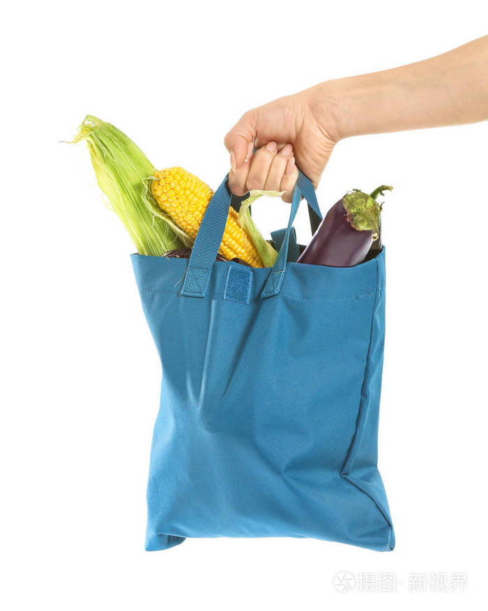白色背景的绿色环保袋中的女性手和新鲜蔬菜