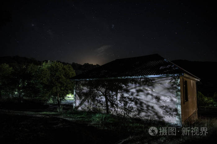 中古老的神秘建筑树木在夜晚和月亮在一起超现实的灯光恐怖万圣节概念