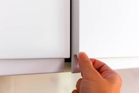 用手打开柜门的人.照片