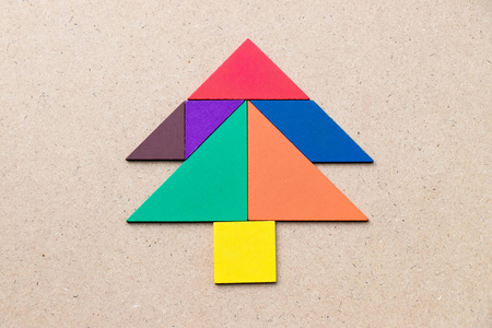 木头背景上松树或圣诞树形状的彩色七巧板照片