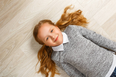 躺在地板上的小女孩的俯视图照片