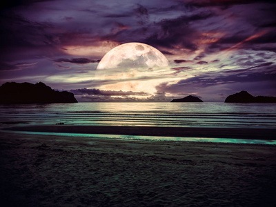 夜晚宁静海水中的小船和月亮的风景