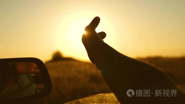 摄图新视界>照片>人物>在美丽的夕阳下,司机们手拿着车窗上的阳光玩耍