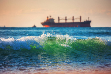 日出时的海浪在日出时航行的货船和海浪运输物流,航运照片
